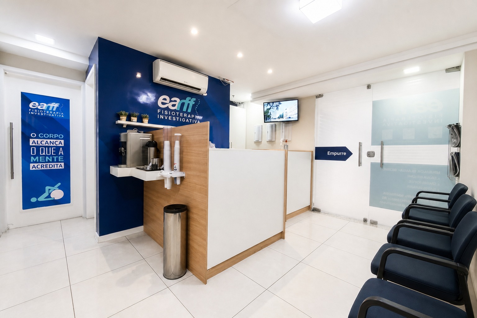 Recepção da unidade EARFF Niterói, balcão de atendimento em madeira e branco com parede azul-marinho com logo EARFF, cadeiras de espera azul-marinho, ambiente clean e iluminado, fotografia realista
